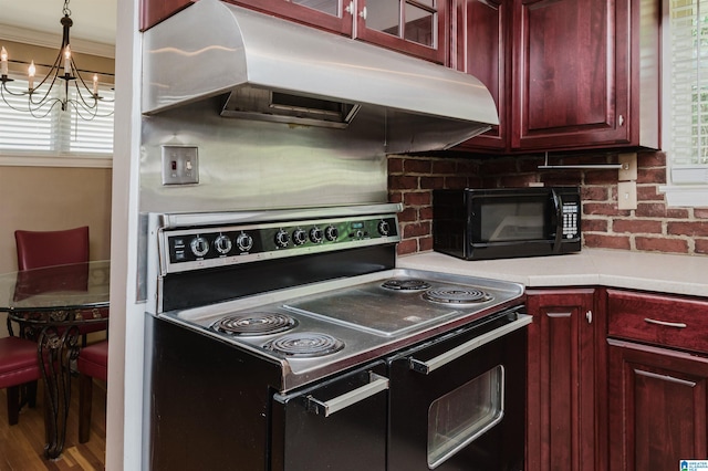 kitchen featuring hanging light fixtures, electric range oven, a wealth of natural light, and wood-type flooring