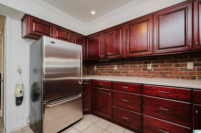 kitchen featuring decorative backsplash, stainless steel refrigerator, light tile patterned floors, and ornamental molding