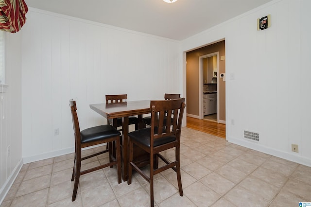 dining space featuring light hardwood / wood-style flooring and crown molding