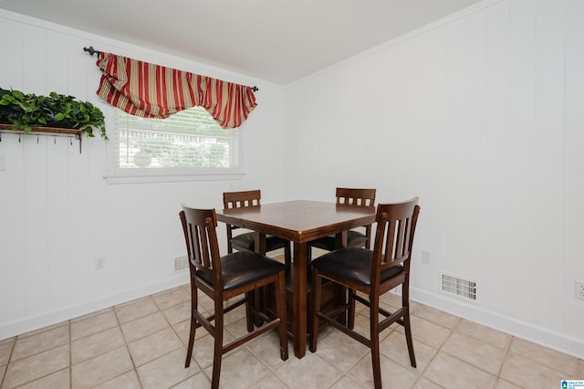 dining room with light tile patterned floors and ornamental molding