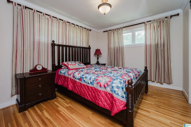 bedroom with light wood-type flooring and ornamental molding