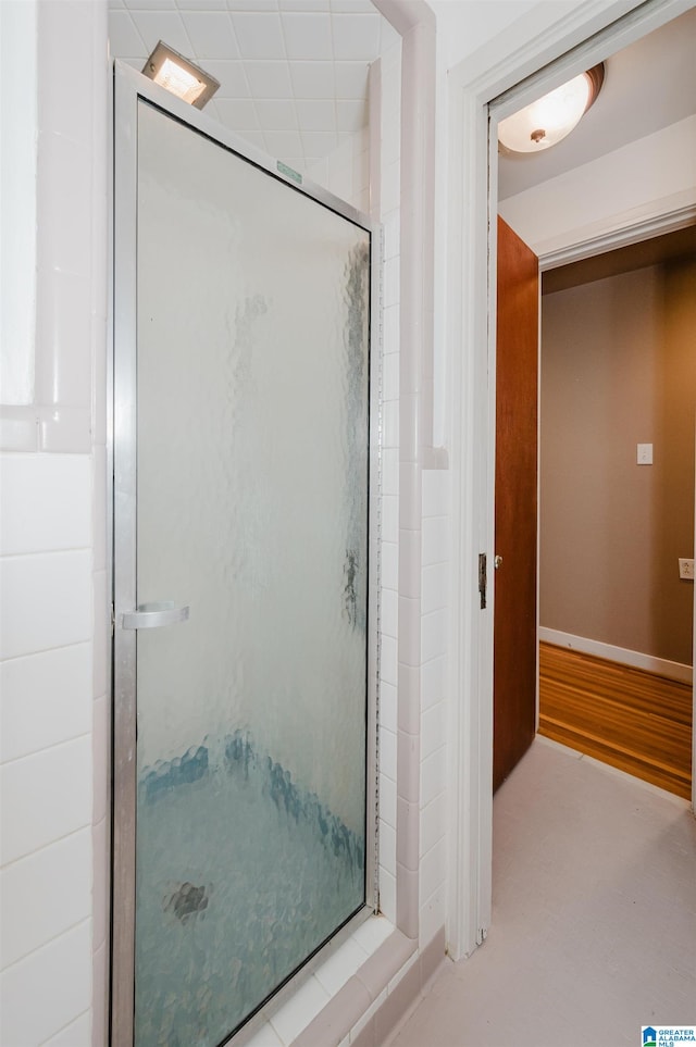 bathroom with a shower with door and hardwood / wood-style flooring