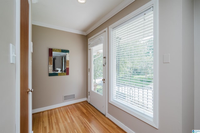 doorway to outside featuring crown molding and light wood-type flooring