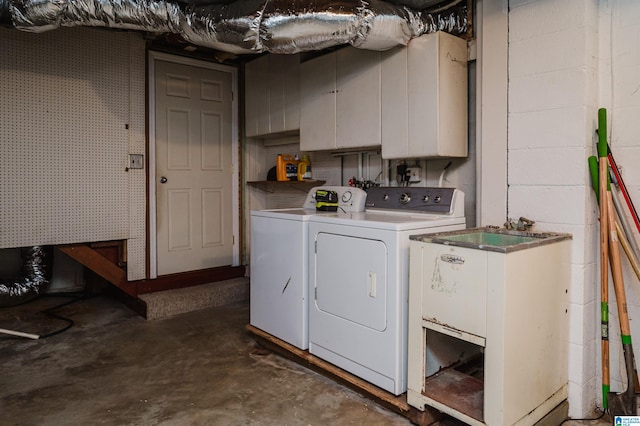 washroom featuring washer and clothes dryer and cabinets