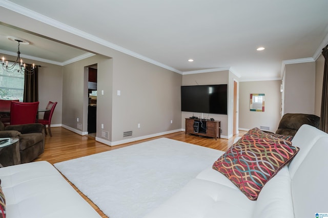 living room with a notable chandelier, light hardwood / wood-style flooring, and crown molding