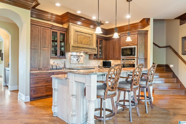 kitchen featuring a center island, light hardwood / wood-style flooring, stainless steel appliances, and backsplash