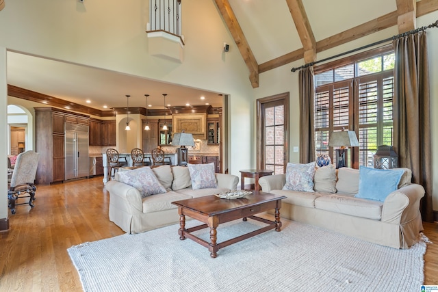 living room with high vaulted ceiling, beamed ceiling, and light hardwood / wood-style floors