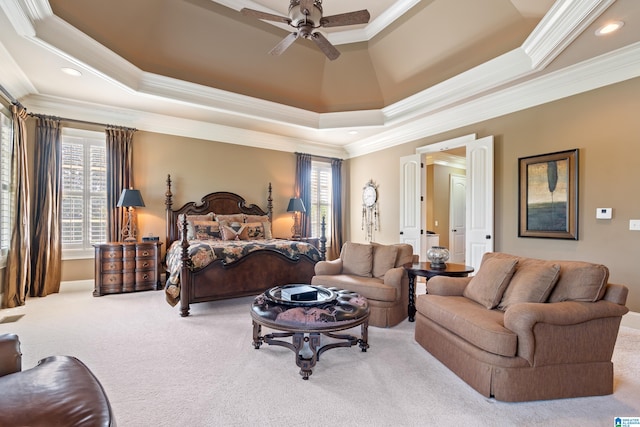 carpeted bedroom with ceiling fan, a raised ceiling, and ornamental molding