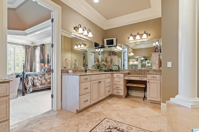 bathroom with ornate columns, vanity, tile patterned floors, and a raised ceiling