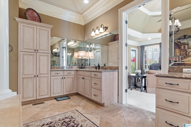 bathroom featuring decorative columns, tile patterned floors, vanity, a raised ceiling, and ornamental molding