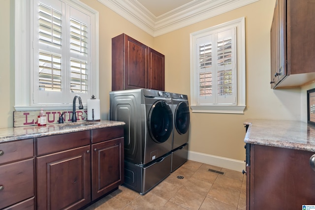 clothes washing area with light tile patterned floors, washing machine and dryer, cabinets, sink, and ornamental molding