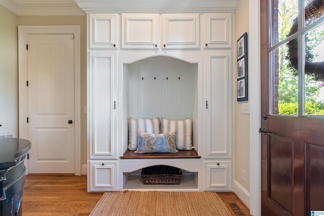 mudroom with crown molding and light wood-type flooring