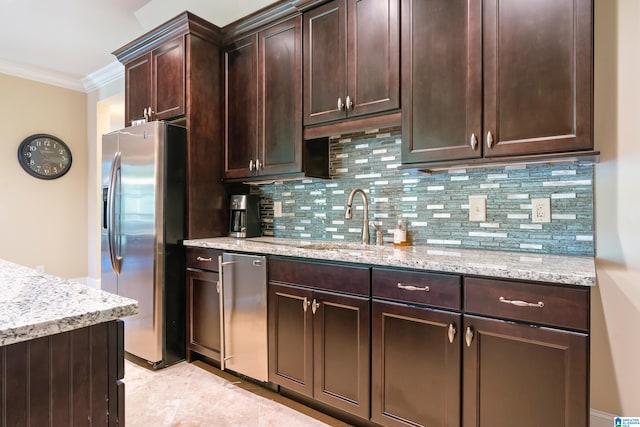 kitchen featuring dark brown cabinets, backsplash, light stone counters, appliances with stainless steel finishes, and sink