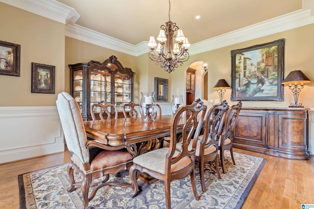 dining room featuring ornamental molding, light hardwood / wood-style flooring, and a chandelier