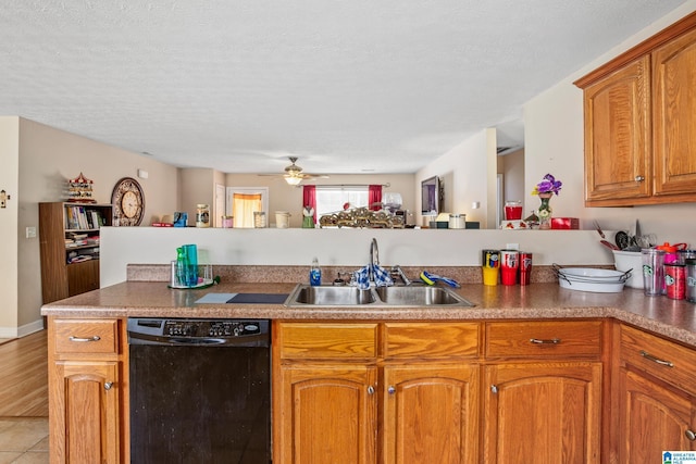kitchen featuring a sink, a ceiling fan, dishwasher, a textured ceiling, and brown cabinetry