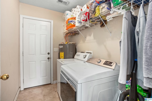 clothes washing area with electric water heater, independent washer and dryer, light tile patterned flooring, visible vents, and laundry area