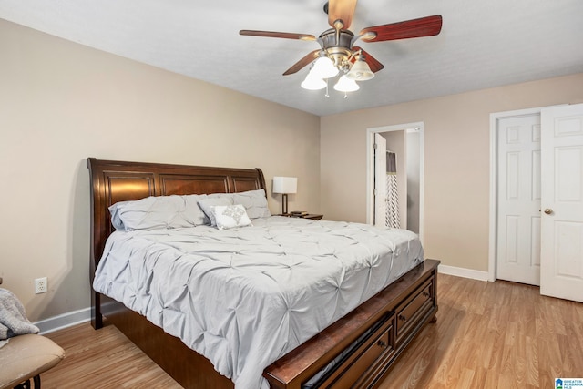 bedroom with baseboards, ceiling fan, and light wood-type flooring