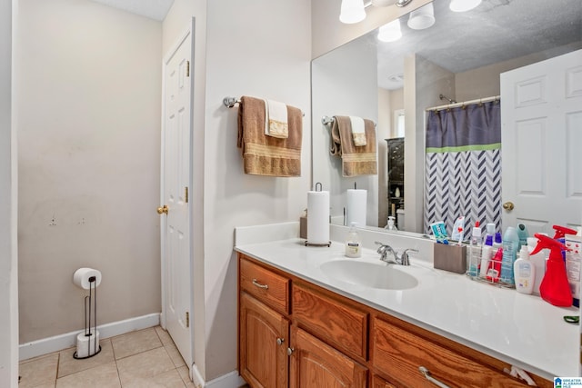 full bath featuring tile patterned flooring, vanity, baseboards, and a shower with shower curtain