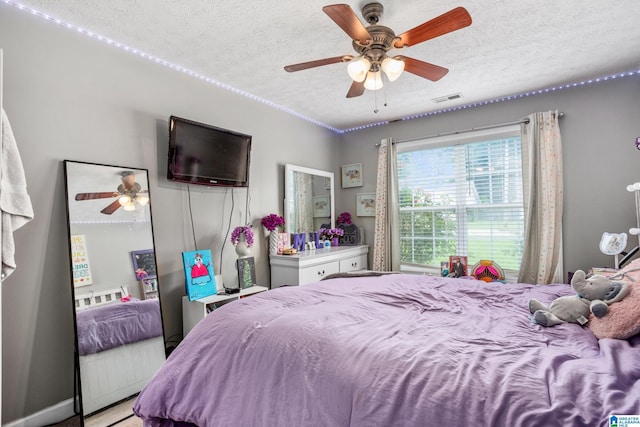 bedroom featuring visible vents, ceiling fan, and a textured ceiling