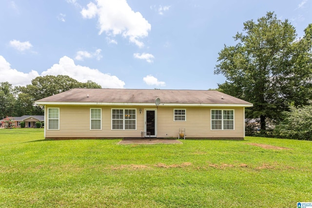 rear view of property with a patio and a lawn