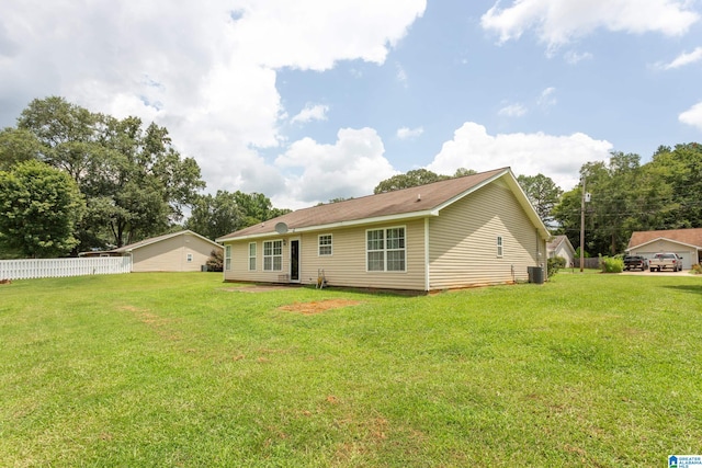 back of house featuring fence and a yard