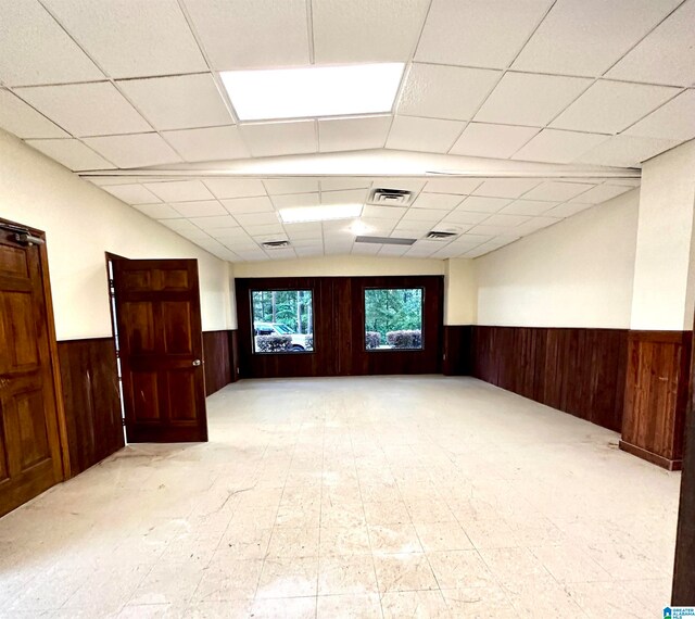 empty room with light tile patterned flooring, a paneled ceiling, and french doors