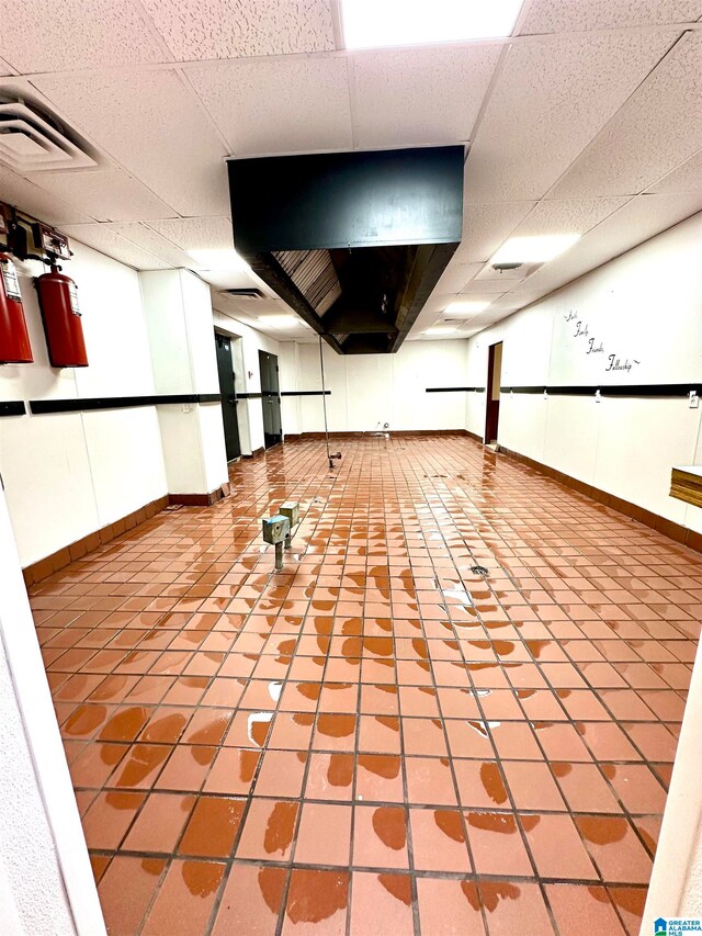 interior space featuring light tile patterned flooring and a paneled ceiling