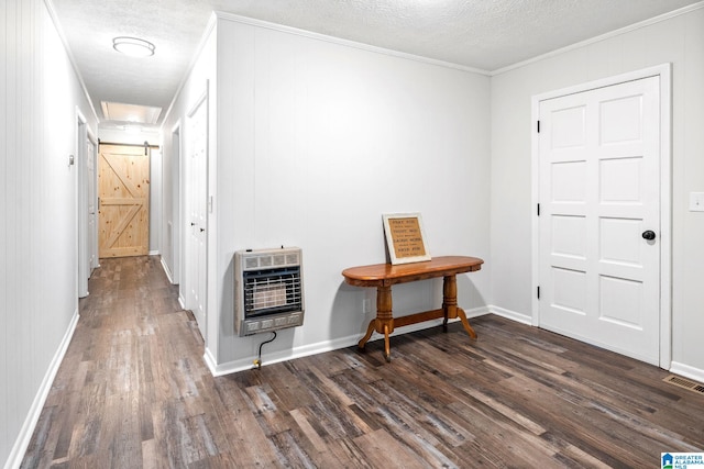 corridor featuring ornamental molding, heating unit, and a textured ceiling