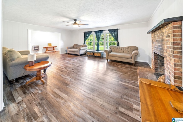 living room with ceiling fan, a fireplace, dark hardwood / wood-style floors, and a textured ceiling