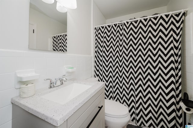 bathroom with tile walls, toilet, vanity, and a shower with shower curtain