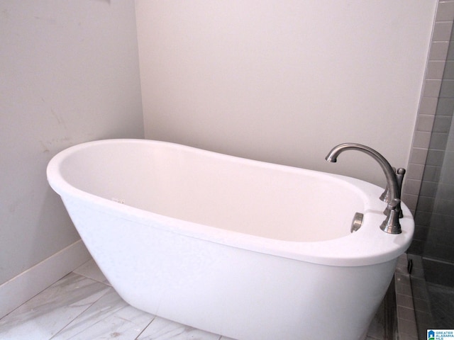 bathroom featuring tile patterned floors and a tub