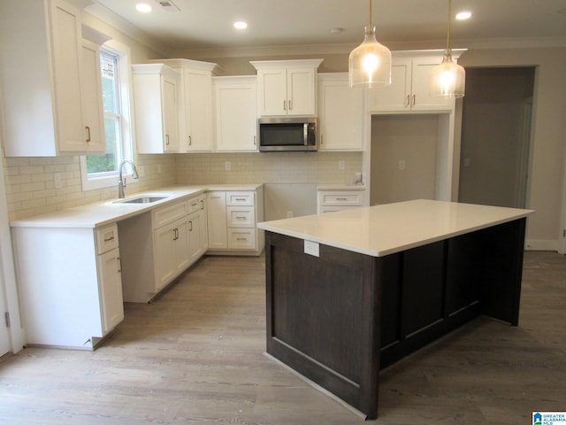 kitchen featuring decorative backsplash, light hardwood / wood-style flooring, and sink