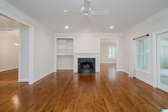 unfurnished living room with dark wood-type flooring, ceiling fan, a high end fireplace, and ornamental molding