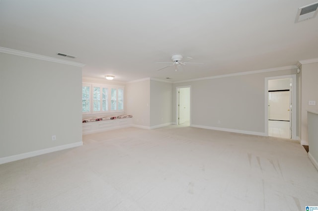 spare room featuring light carpet, ceiling fan, and crown molding