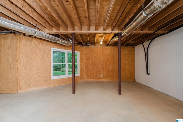 basement featuring wooden walls