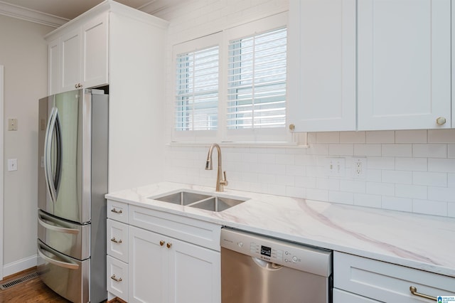 kitchen featuring backsplash, appliances with stainless steel finishes, sink, and white cabinetry