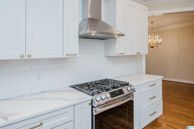 kitchen featuring wall chimney exhaust hood, white cabinetry, backsplash, ornamental molding, and gas range