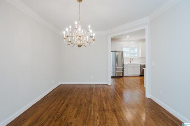 unfurnished dining area with wood-type flooring, sink, a chandelier, and ornamental molding