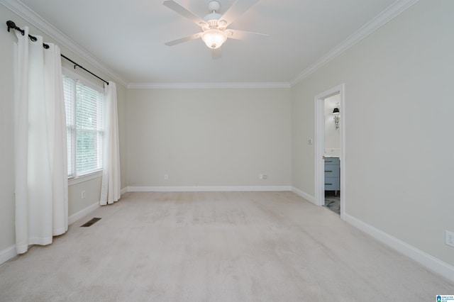 spare room featuring ceiling fan, ornamental molding, and light carpet