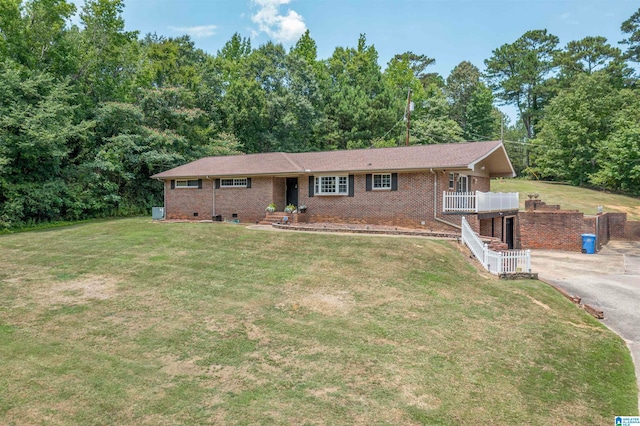 ranch-style home with a wooden deck and a front yard