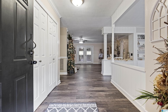 foyer entrance with decorative columns, dark hardwood / wood-style floors, and ceiling fan