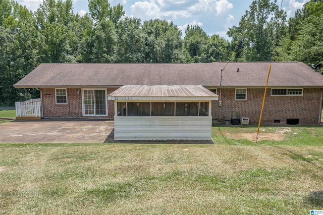 view of front facade featuring a patio, a sunroom, a front yard, and central air condition unit