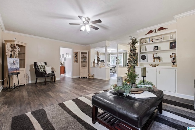 living room with ornamental molding, built in shelves, hardwood / wood-style flooring, and ceiling fan