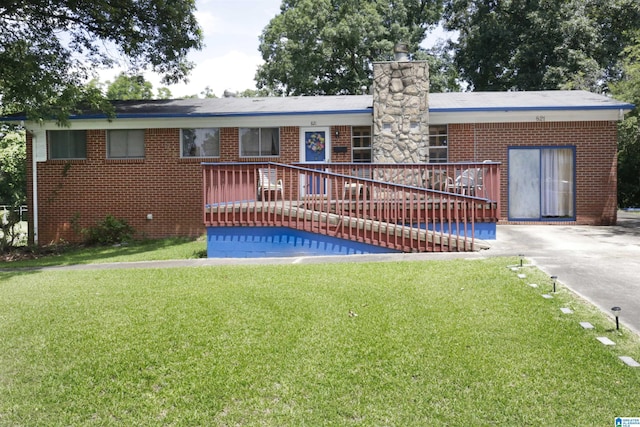 back of house featuring a lawn and a wooden deck