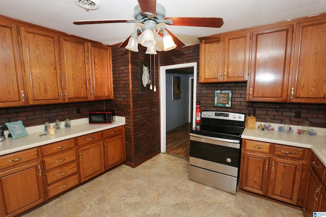 kitchen featuring stainless steel range with electric cooktop, decorative backsplash, and ceiling fan