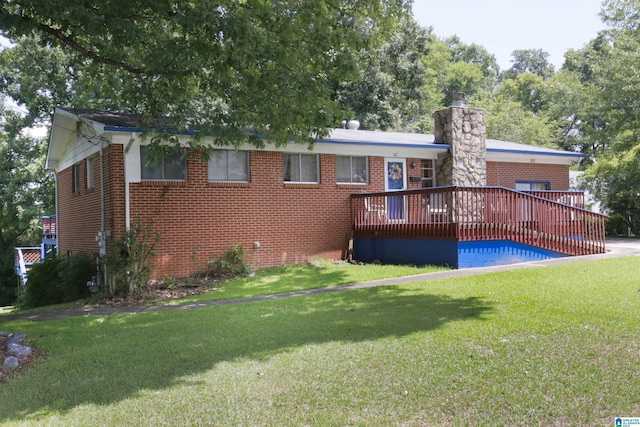 back of property with a yard and a wooden deck