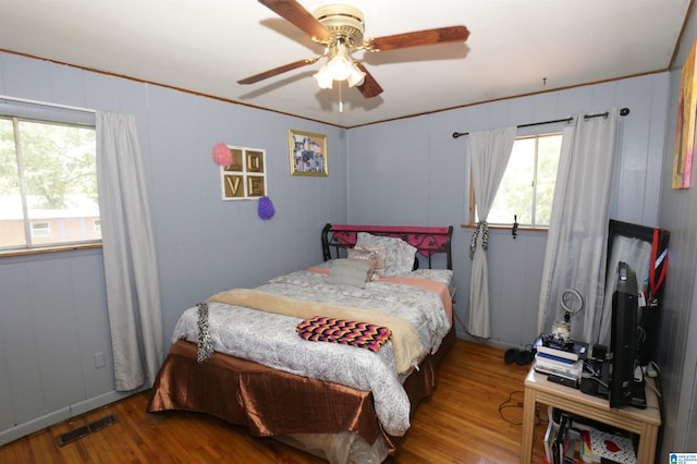 bedroom featuring ceiling fan, hardwood / wood-style floors, and crown molding