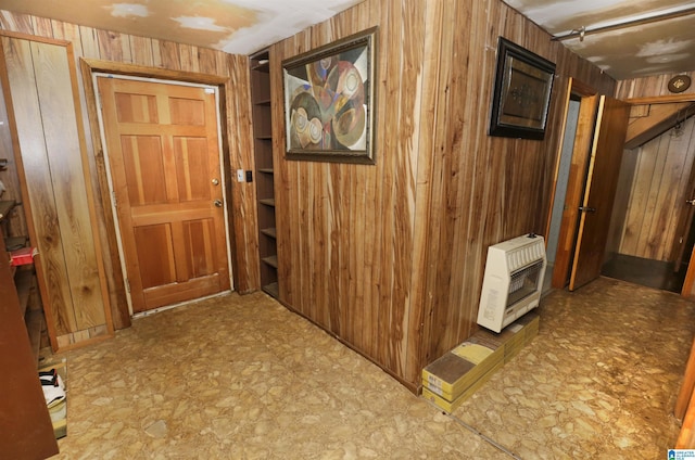 hallway featuring wood walls and heating unit