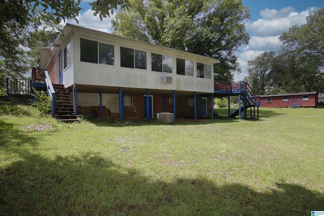 rear view of house with a wooden deck, central air condition unit, and a lawn