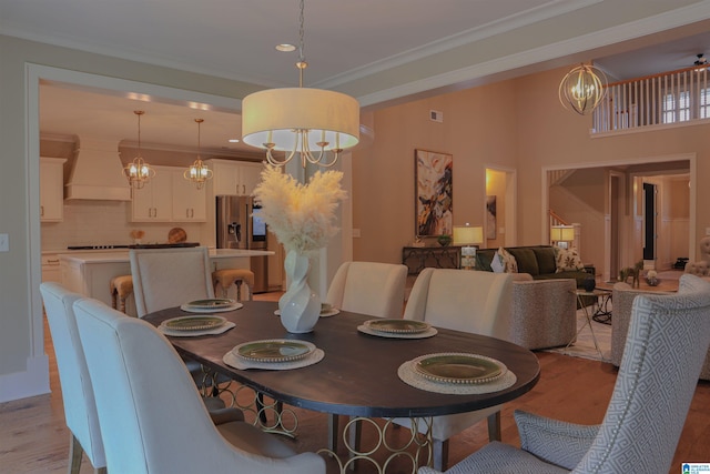 dining space featuring an inviting chandelier, crown molding, and light hardwood / wood-style flooring